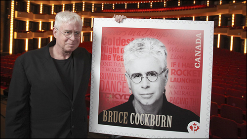 Bruce Cockburn poses with his forthcoming stamp, which will be issued June 30